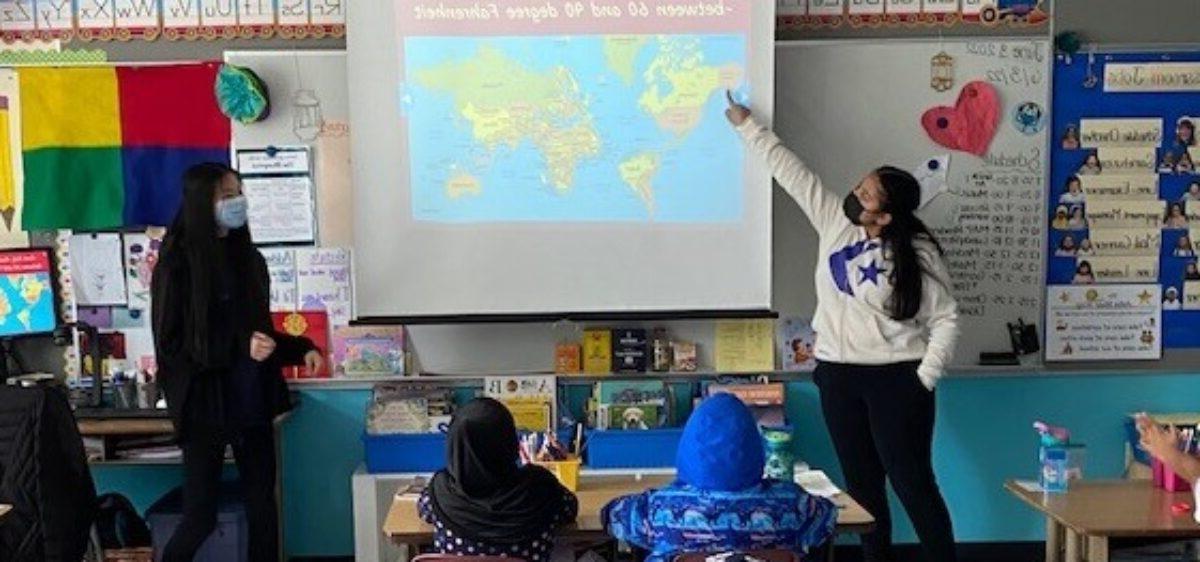 两名实习教师站在小学生面前看世界地图